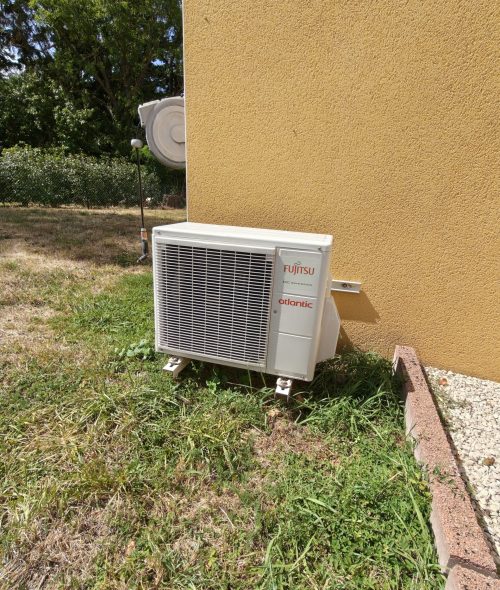 Artisan électricien posant une climatisation réversible à Charlieu